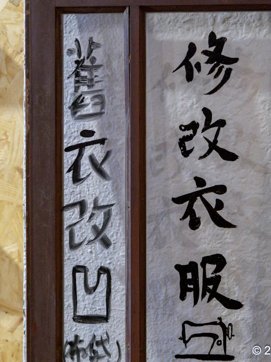 一群人圍著大桌舉著自己做的布包